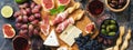 Italian antipasti wine snacks set. Prosciutto,red wine, cheese, olives, grapes, figs and cheese. Top view, banner Royalty Free Stock Photo