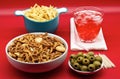 Italian aperitive: glass of frozen cocktail with green pitted olves, fries and salted pretzels snack for party