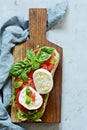 Italian Appetizer Bruschetta toast with Caprese Salad on a wooden board on a blue background