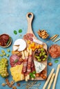 Italian appetizers or antipasto set with gourmet food on kitchen table top view. Delicatessen of cheese, olives and meat snacks