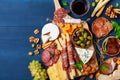 Italian appetizers or antipasto set with gourmet food on wooden kitchen table top view. Delicatessen of cheese and meat snacks Royalty Free Stock Photo