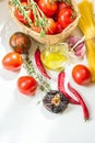 Italian arrabiata pasta ingredients for cooking. Spaghetti tomatoes hot chili peppers culinary herbs olive oil on white table