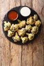 Italian baked broccoli appetizer with parmesan served with sauces. Vertical top view