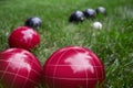 Italian bocce ball, bocci or boccie red and blue white balls on green lawn close up. an ancient games played in the Roman Empire Royalty Free Stock Photo
