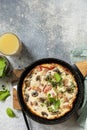 Rustic omelette (frittata) with mushrooms and bacon on a cast iron pan. View from above. Copy space