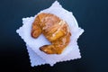Italian breakfast. Top view to fresh traditional french croissant with glaze on white napkins. Black background with