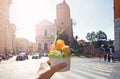 Italian bright sweet ice cream gelato cone with different flavors held in hand on the background of Piazza in Rome