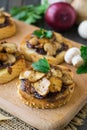 Italian bruschetta with champignons and caramelized red onions on a wooden background. Selective focus Royalty Free Stock Photo