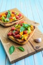 Italian bruschetta with chopped tomatoes and basil on wooden cutting board