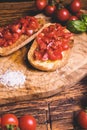 Italian bruschetta, toasted bred with fresh tomato and basil on woody vintage table