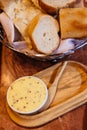 Italian butter in white cup served with fresh baked bread in basket
