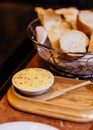 Italian butter in white cup served with fresh baked bread in basket