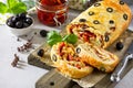 Italian cake pizza with salami cheese, greens, black olives and sun-dried tomato on gray stone table. Italian food background Royalty Free Stock Photo