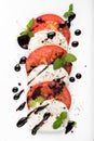 Italian Caprese salad with Mozzarella Tomato Oregano Black Pepper and Balsamic Vinegar on White Plate