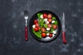 Fresh italian caprese salad with mozzarella and tomatoes on black plate over dark stone background with copy space, flat Royalty Free Stock Photo