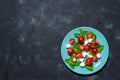 Fresh italian caprese salad with mozzarella and tomatoes on blue plate over dark stone background with copy space, flat Royalty Free Stock Photo