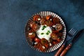 Italian caprese salad with sliced tomatoes, mozzarella cheese, olive oil on dark background. Top view. Black tomato Royalty Free Stock Photo