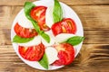 Italian caprese salad with tomatoes, mozzarella cheese and basil on wooden table. Top view Royalty Free Stock Photo