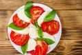 Italian caprese salad with tomatoes, mozzarella cheese and basil on wooden table. Top view Royalty Free Stock Photo