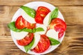 Italian caprese salad with tomatoes, mozzarella cheese and basil on a wooden table. Top view Royalty Free Stock Photo