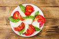 Italian caprese salad with tomatoes, mozzarella cheese and basil on a wooden table. Top view Royalty Free Stock Photo