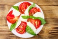 Italian caprese salad with tomatoes, mozzarella cheese and basil on wooden table. Top view Royalty Free Stock Photo