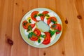 Italian caprese salad with tomatoes, mozzarella cheese and basil on wooden table. Top view Royalty Free Stock Photo