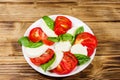 Italian caprese salad with tomatoes, mozzarella cheese and basil on wooden table. Top view Royalty Free Stock Photo