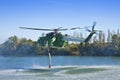 Italian CFS 103 fire fighting helicopter flying over a lake to collects water through a suction tube to extinguish a fire Royalty Free Stock Photo