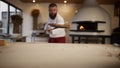 Italian chef making pizza in restaurant. Pastry cook taking out food in oven. Royalty Free Stock Photo