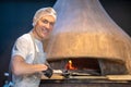 Italian chief-cooker baking pizza in the restaurant