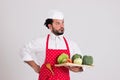 Italian Chief cook in Red Apron is Holding Wicker Tray with Veget