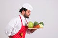 Italian Chief cook in Red Apron is Holding Wicker Tray with Vegetables