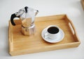 Italian coffee espresso maker moka pot and white cup of coffee on bamboo wooden tray Royalty Free Stock Photo