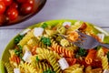 Italian colorful pasta rotini with cherry tomatoes on white wooden background Royalty Free Stock Photo