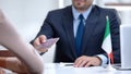 Italian consular officer giving passport to immigrant, citizenship for refugee Royalty Free Stock Photo