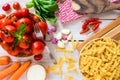 Italian cooking preparation flat lay image with pasta, tomato and other ingredients on white wooden table Royalty Free Stock Photo