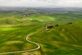 Italian countryside view with a road to a hilltop home in Tuscany.