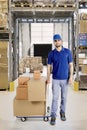 Italian courier with boxes in the warehouse