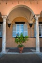 an Italian courtyard with columns, a window with a large vase of citrus in the center Royalty Free Stock Photo