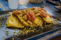 Italian cuisine - pasta - ravioli, served with tomatoes and pistacchio Royalty Free Stock Photo