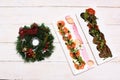 Italian cuisine starters and Christmas wreath on white wooden background