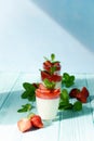 Italian dessert Panakota with strawberry coolies, fresh berries and mint on a blue background with hard shadows. Creamy milk Royalty Free Stock Photo