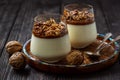 Italian dessert pannacotta in glasses with salted caramel and walnuts. Royalty Free Stock Photo