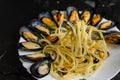 Italian dish with steamed mussels with wine. Close up of spaghetti on a fork. Seafood eating concept.