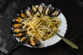 Italian dish with steamed mussels with wine. Close up of spaghetti on a fork. Seafood eating concept. Selective focus