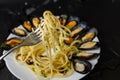 Italian dish with steamed mussels with wine. Close up of spaghetti on a fork. Seafood eating concept.