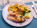Italian dish of tasty steak of baked salmon with french fries