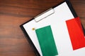 Italian document, mockup for text on clipboard, white sheet of paper in a folder for notes with Italian flag Royalty Free Stock Photo