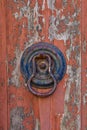 Italian door knocker on old wooden red background Royalty Free Stock Photo